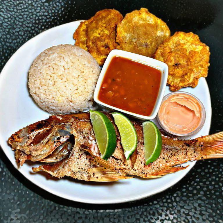 Pescado frito — whole fried fish served with white rice, beans, tostones, and lime at La Garita Restaurant